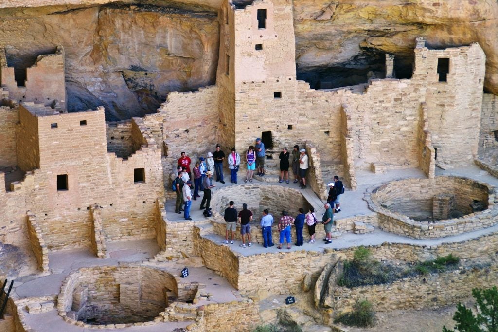 visitors gather around mesa verde cliff dwelling