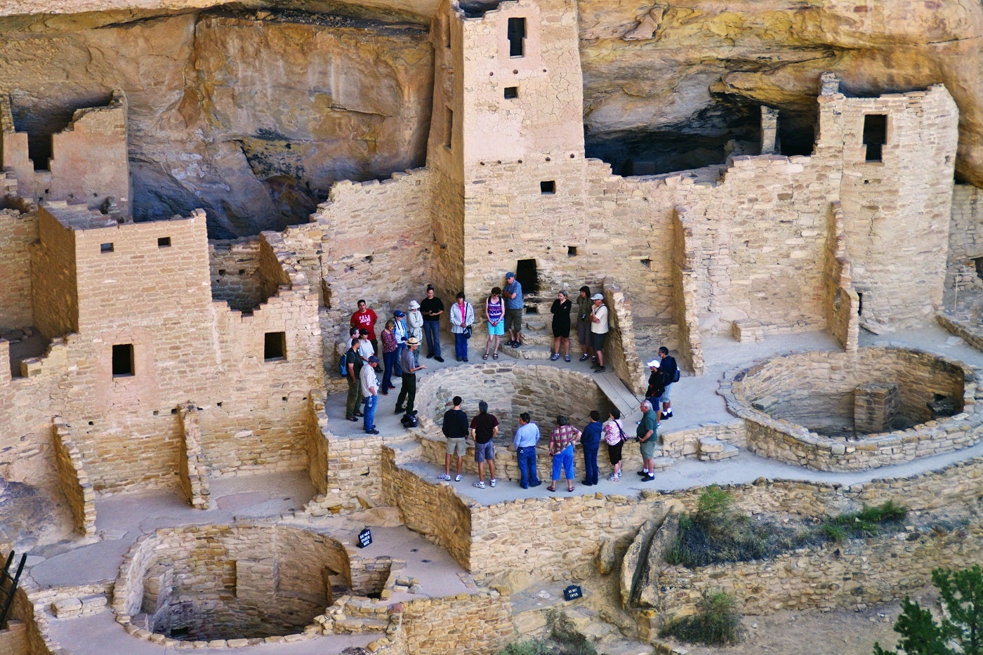 visitors gather around ancient mesa verde cliff dwellings