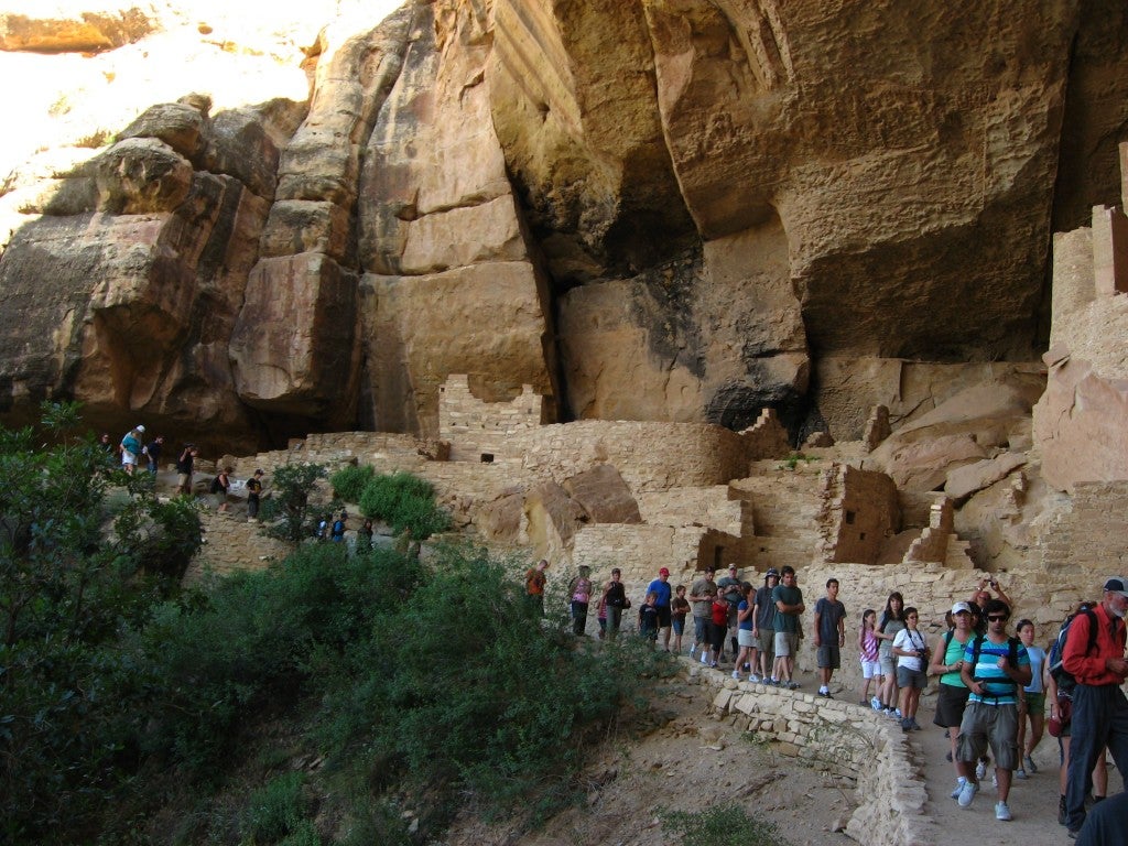 visitors line up during a walking tour of mesa verde cliff dwellings