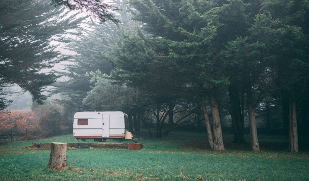 RV trailer parked in the woods.