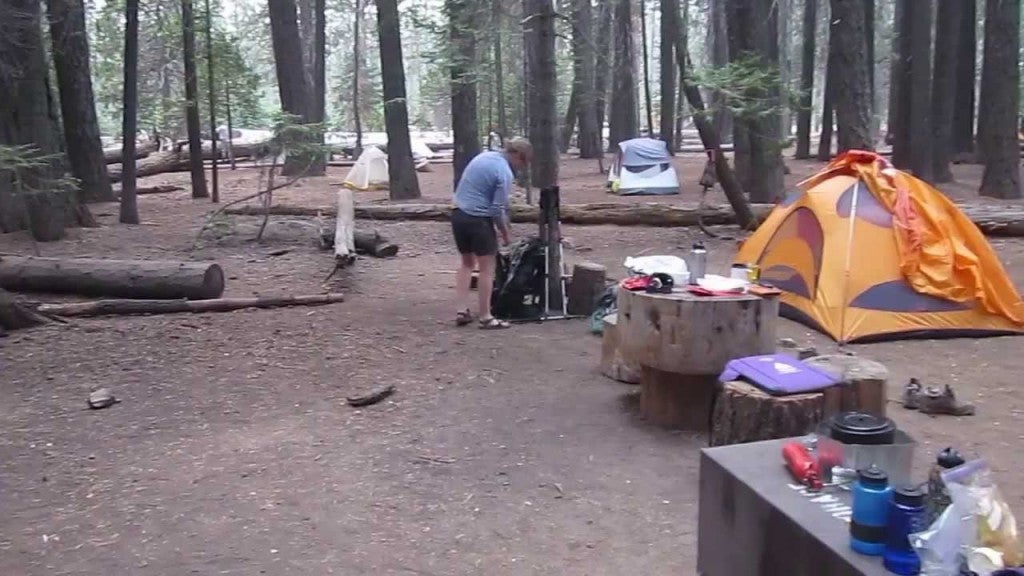 Backpacker setting up camp in the woods.