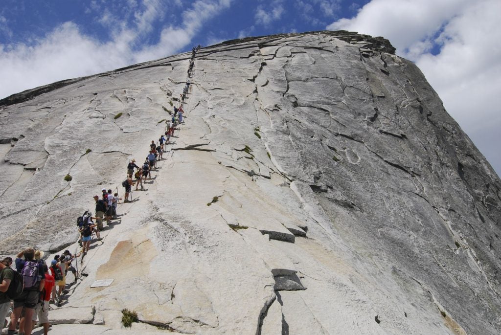 hikers with half dome permits scale Yosemite slope