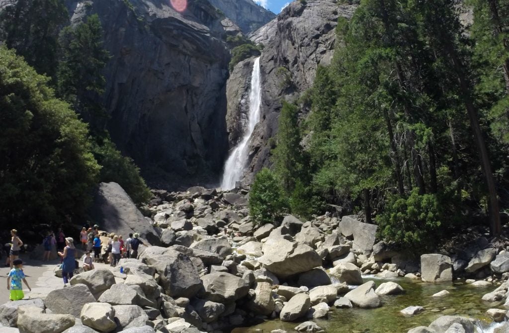 Tourists in front of scenic waterfall.