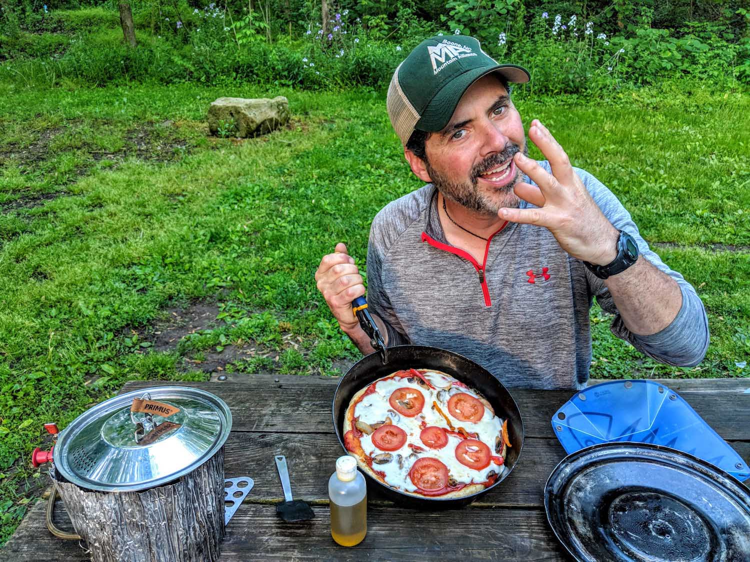 hutch demonstrating his camping kitchen hack for pizza