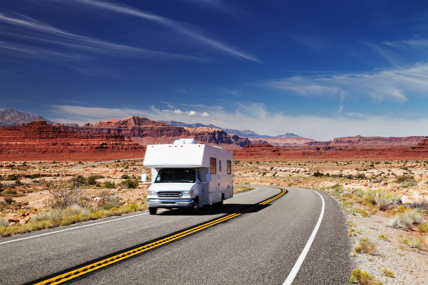 rv traveling down desert road