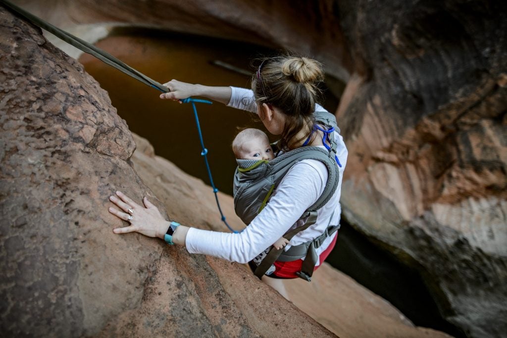 mom repels down slot canyon with baby in chest carrier, via hike it baby