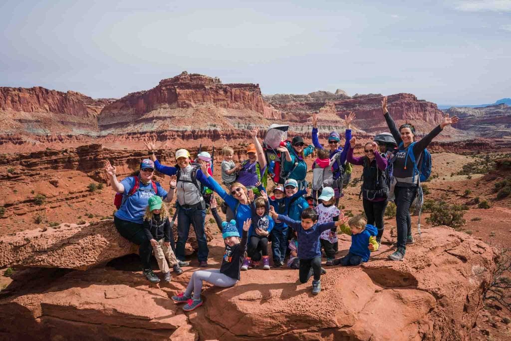 hikers of all ages with arms raised celebrating a grand canyon hike, via hike it baby