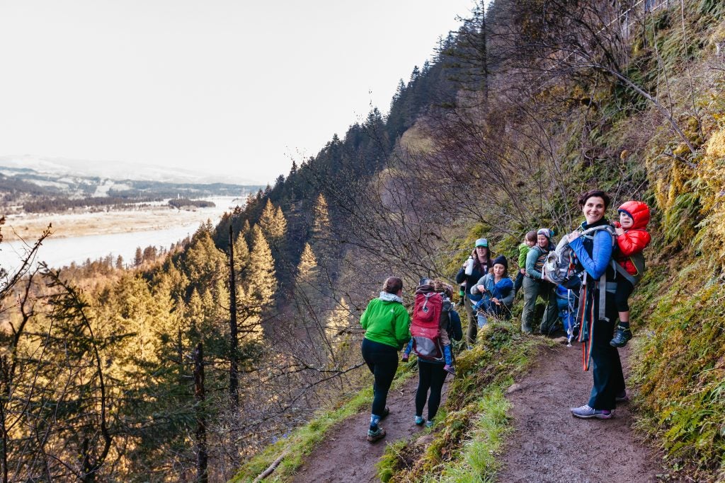 multiple families hiking in jackets on woody hillside, via hike it baby