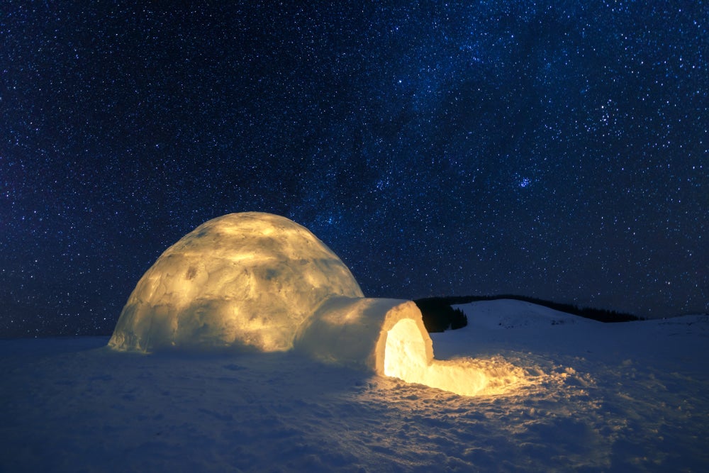 an igloo lit up at nighttime from the inside