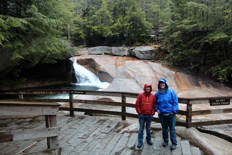 two campers pose in front of the falls at franconia notch state park