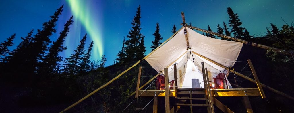 northern lights illuminate the sky above an eco-resort