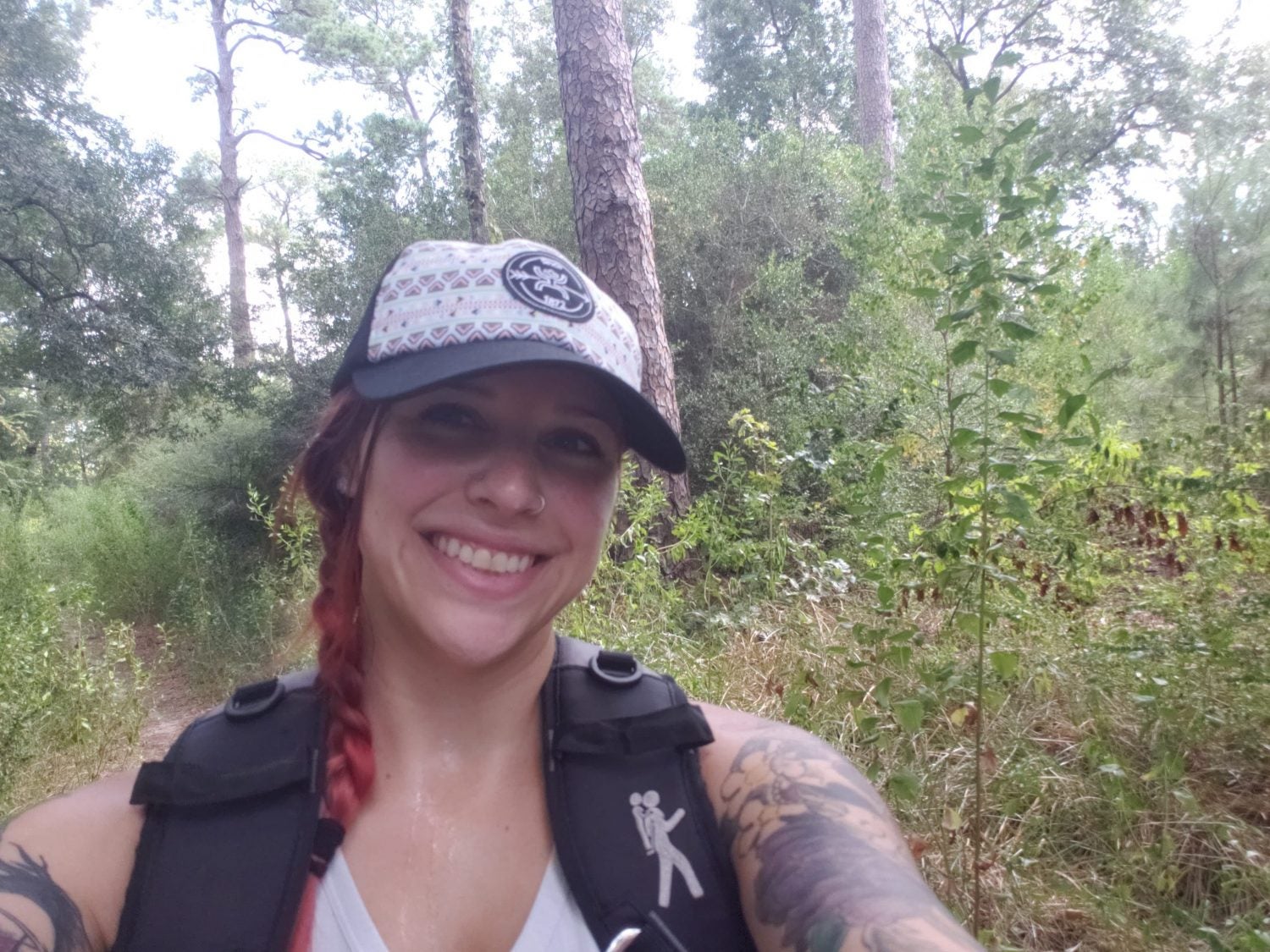 a female hiker poses for a selfie in the wilderness
