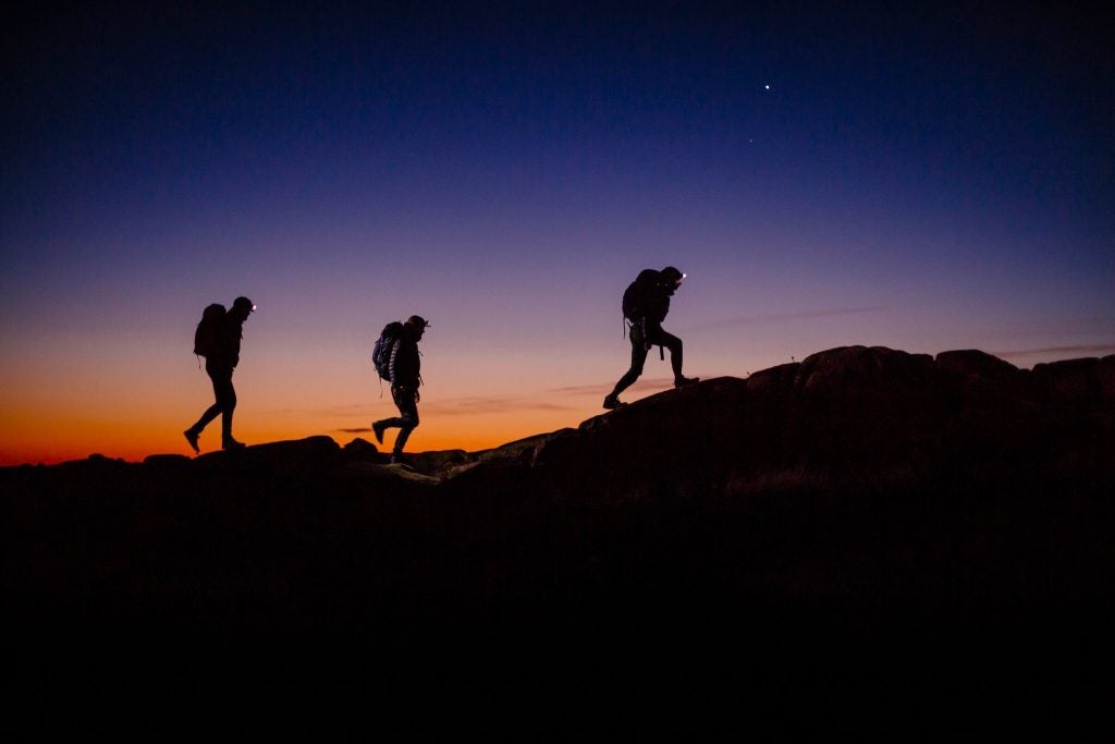3 night hiking silhouettes at sunset