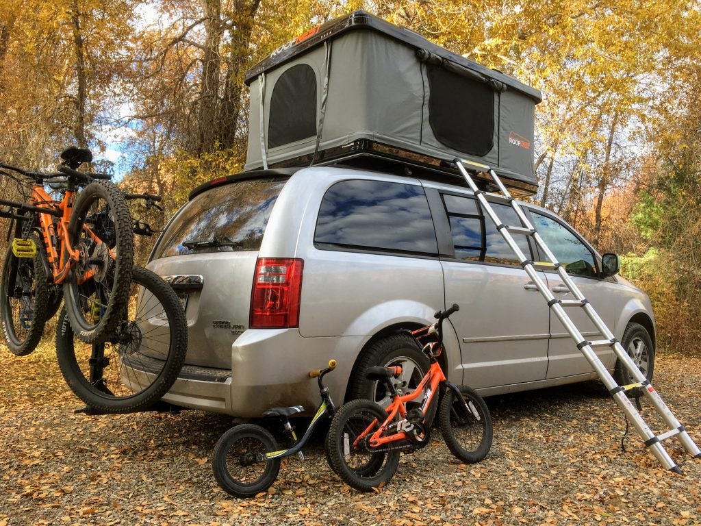 Roofnest hard shell rooftop tent set up on minivan with bikes 