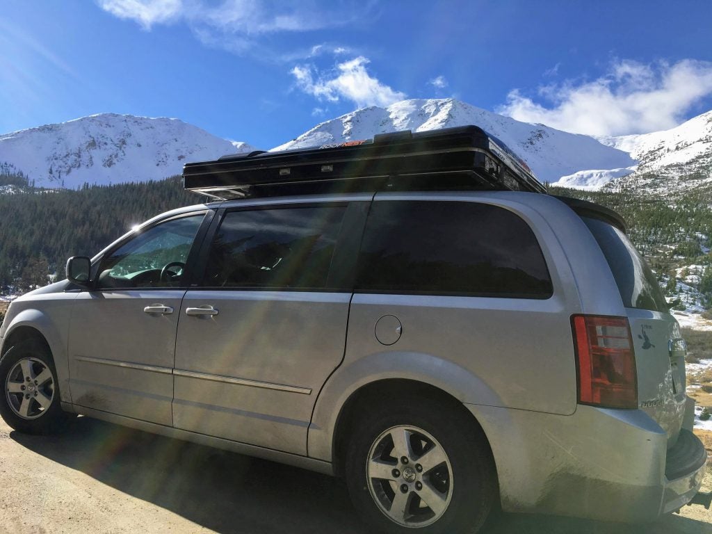 grey mini van in snowy mountainscape 
