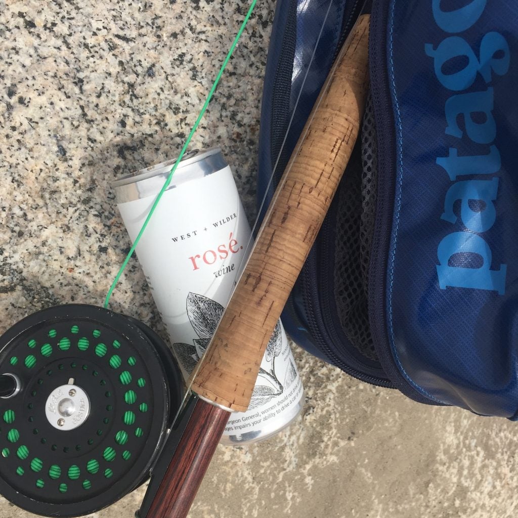 can of rose beneath a fly fishing rod