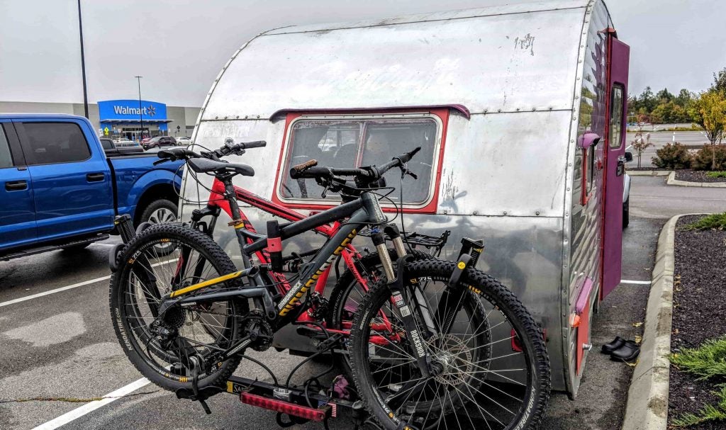 Vintage trailer with bikes attached in the Walmart parking lot.