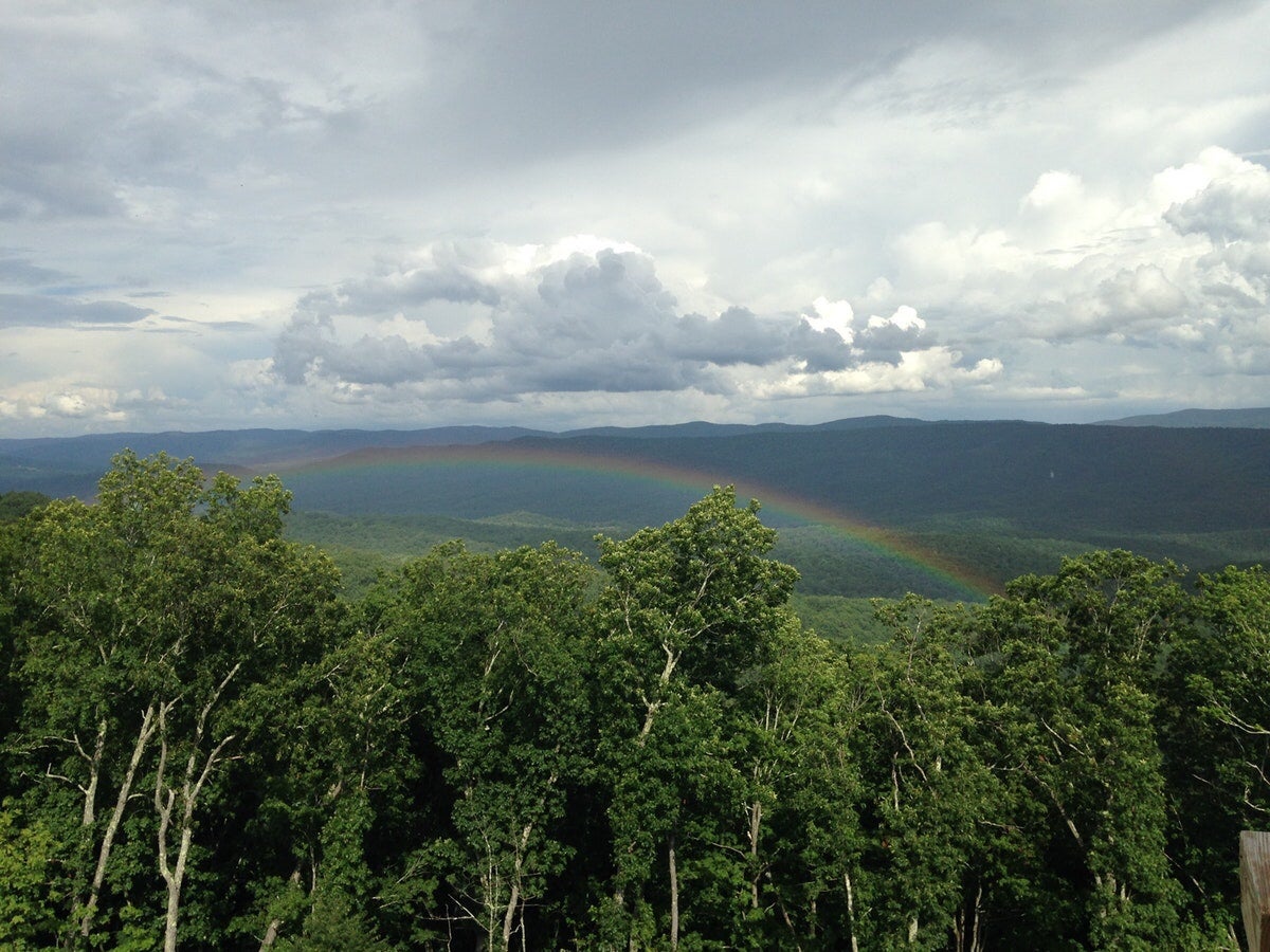 view of a rainbow over the trees taken from greenbrier valley hiking trail