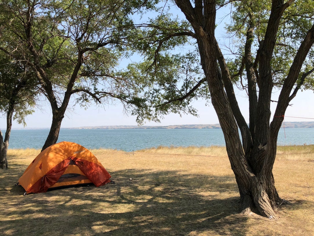 orange tent at lakeside campsite in one of north dakotas state parks