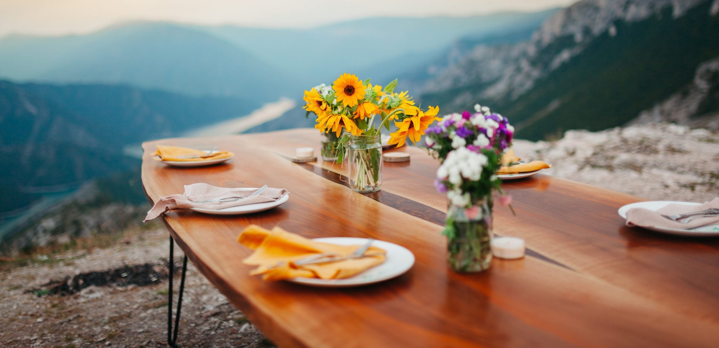 Table setting in the mountains with sunflowers for a thanksgiving buffet celebration