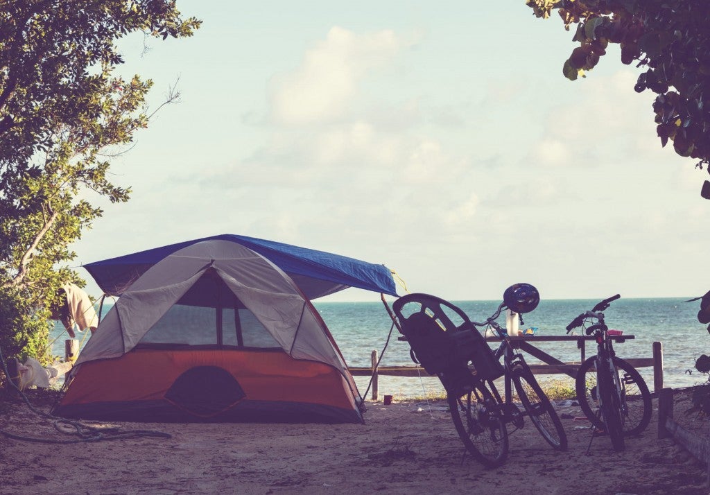a tent and bicycle rest on a sandy myrtle beach campground