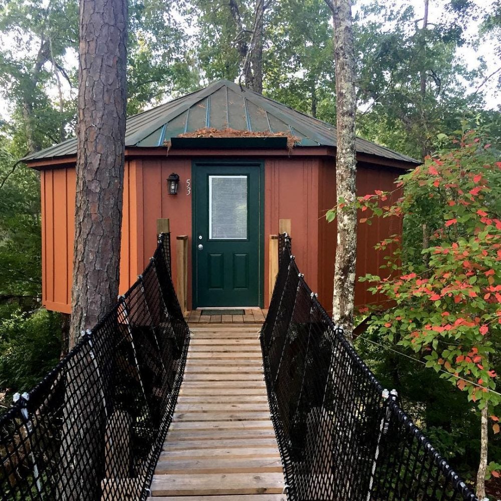 bridge leading to wooded rust colored yurt