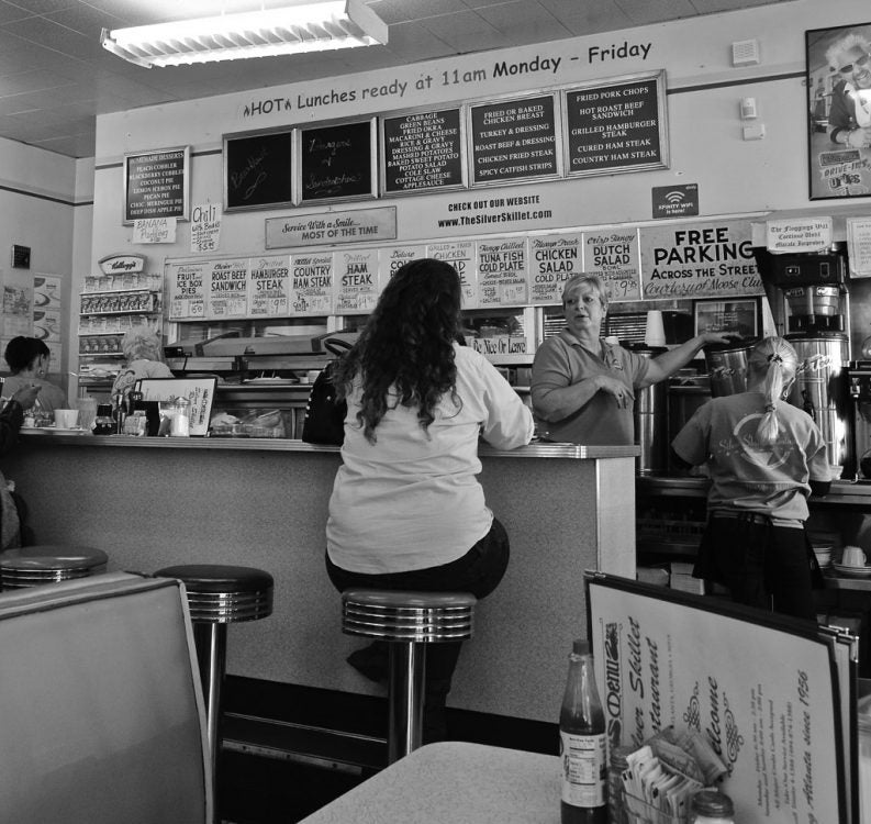 A woman sits at the counter of the Silver Skillet, used as one of many "Ozark" filming locations