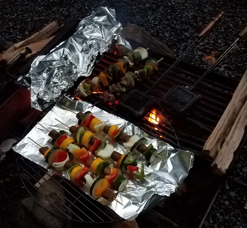 Skewer kabobs cooked over a campfire grill