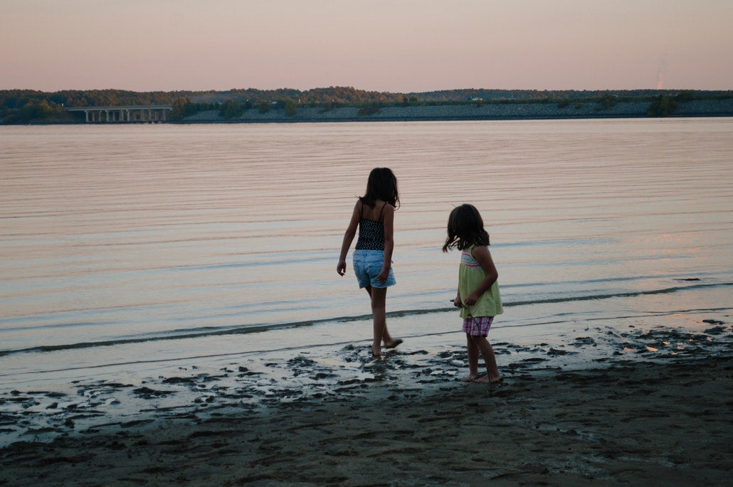 silhouette of two girls playing in the water at sunset on a jordan lake camping trip