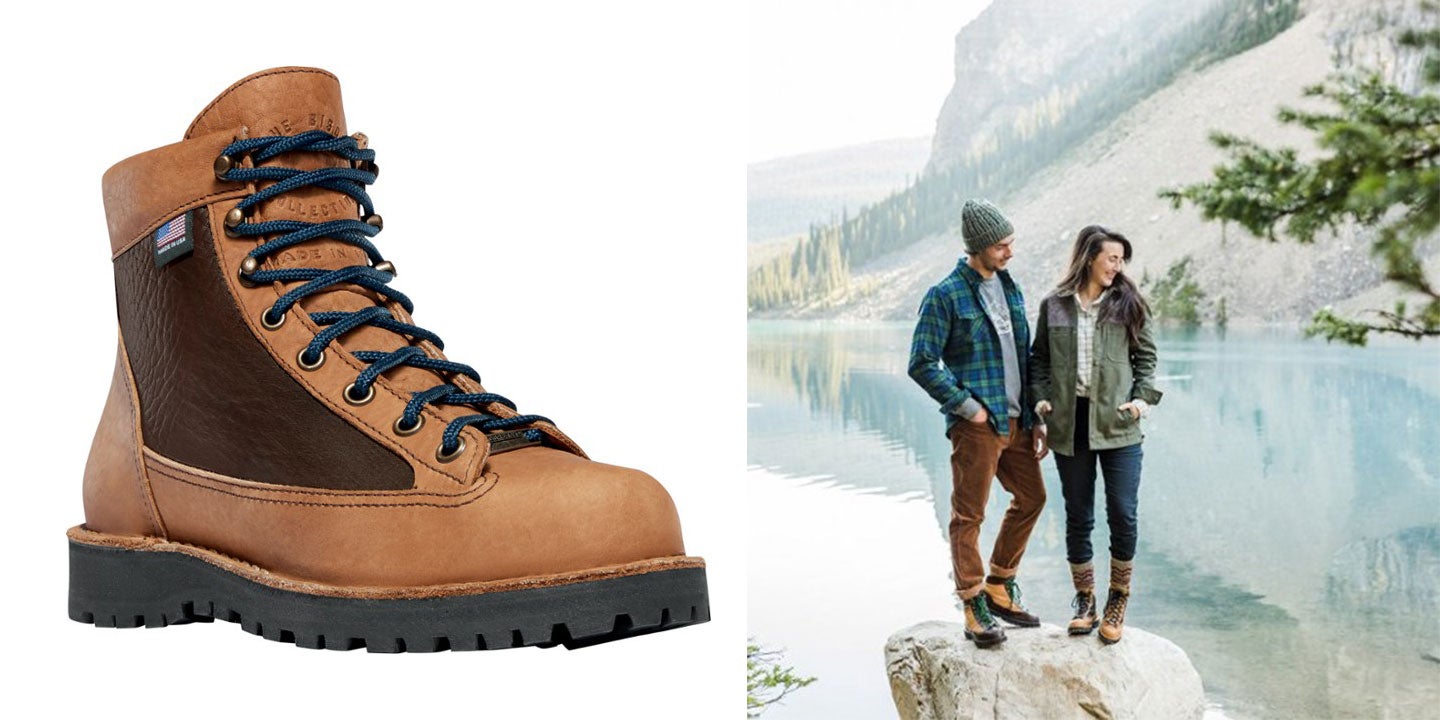 couple poses on a lakeside rock in their brown leather hiking boots