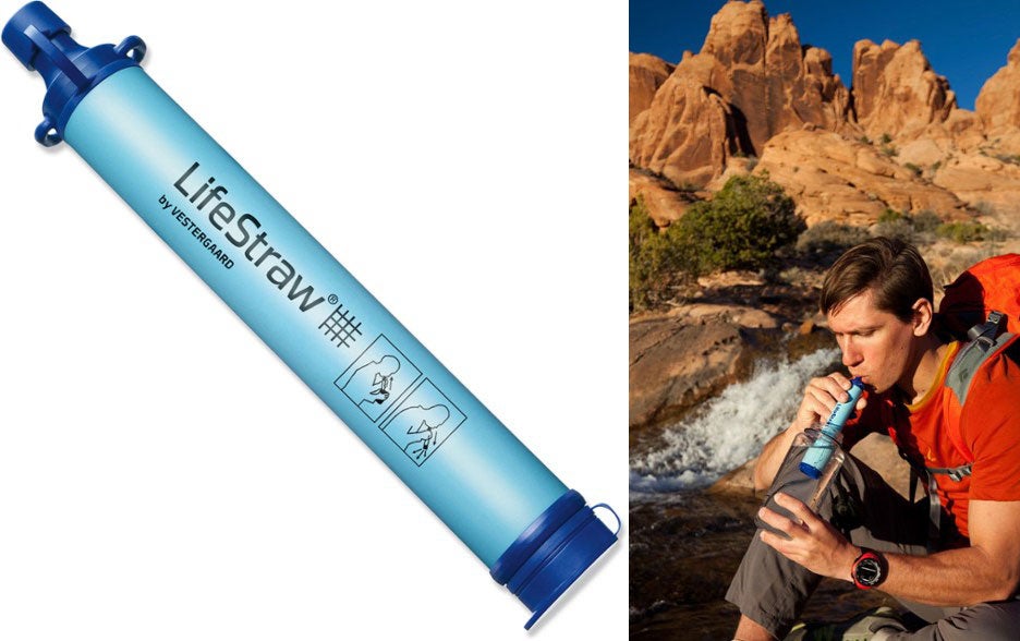 man uses lifestraw in stream beside red rocks