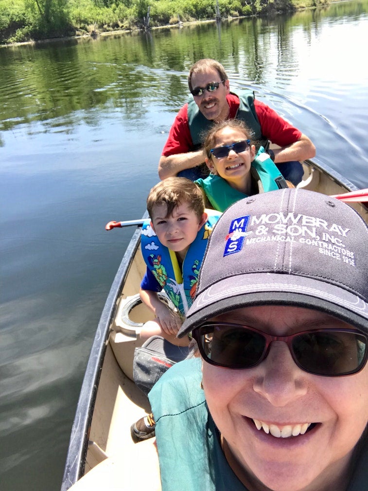 family of kayakers pose for selfie from their kayak on the water at lake metigosh state park