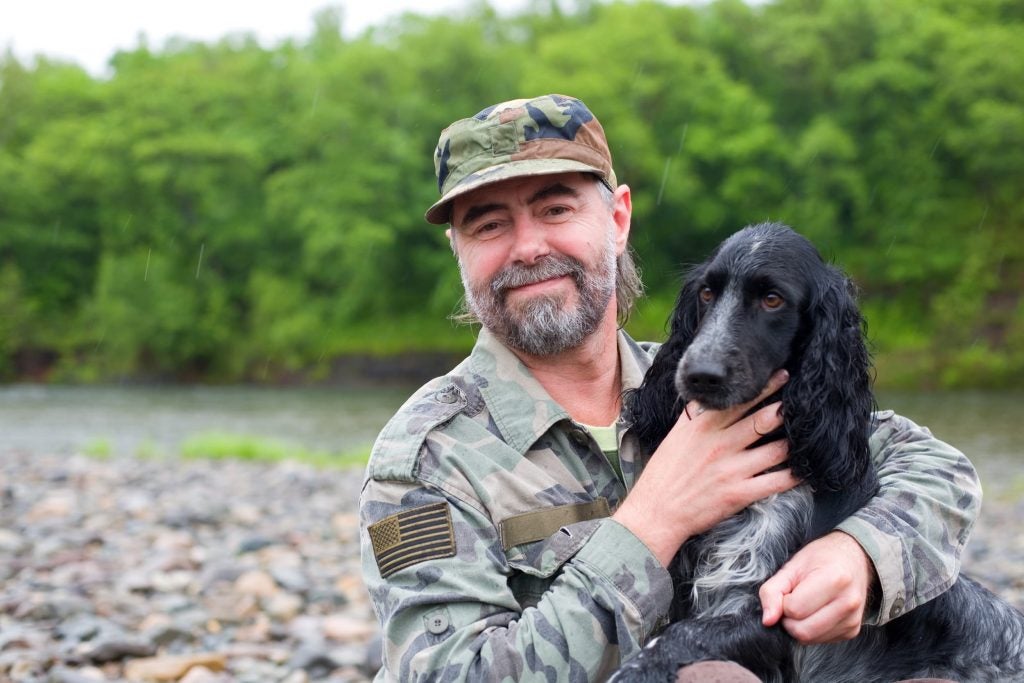 veteran on river bank with dog help veterans heal via wilderness therapy programs