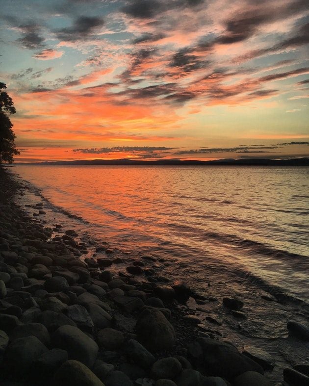 A sunset illuminates a rocky beach of Lake Champlain at Vermont's Grand Isle State Park