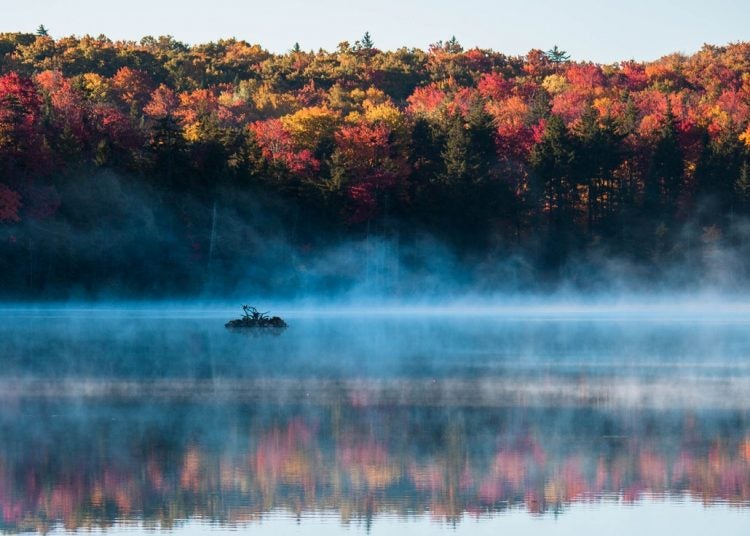 Early morning fog dissapates on a still lake in Woodfors State Park