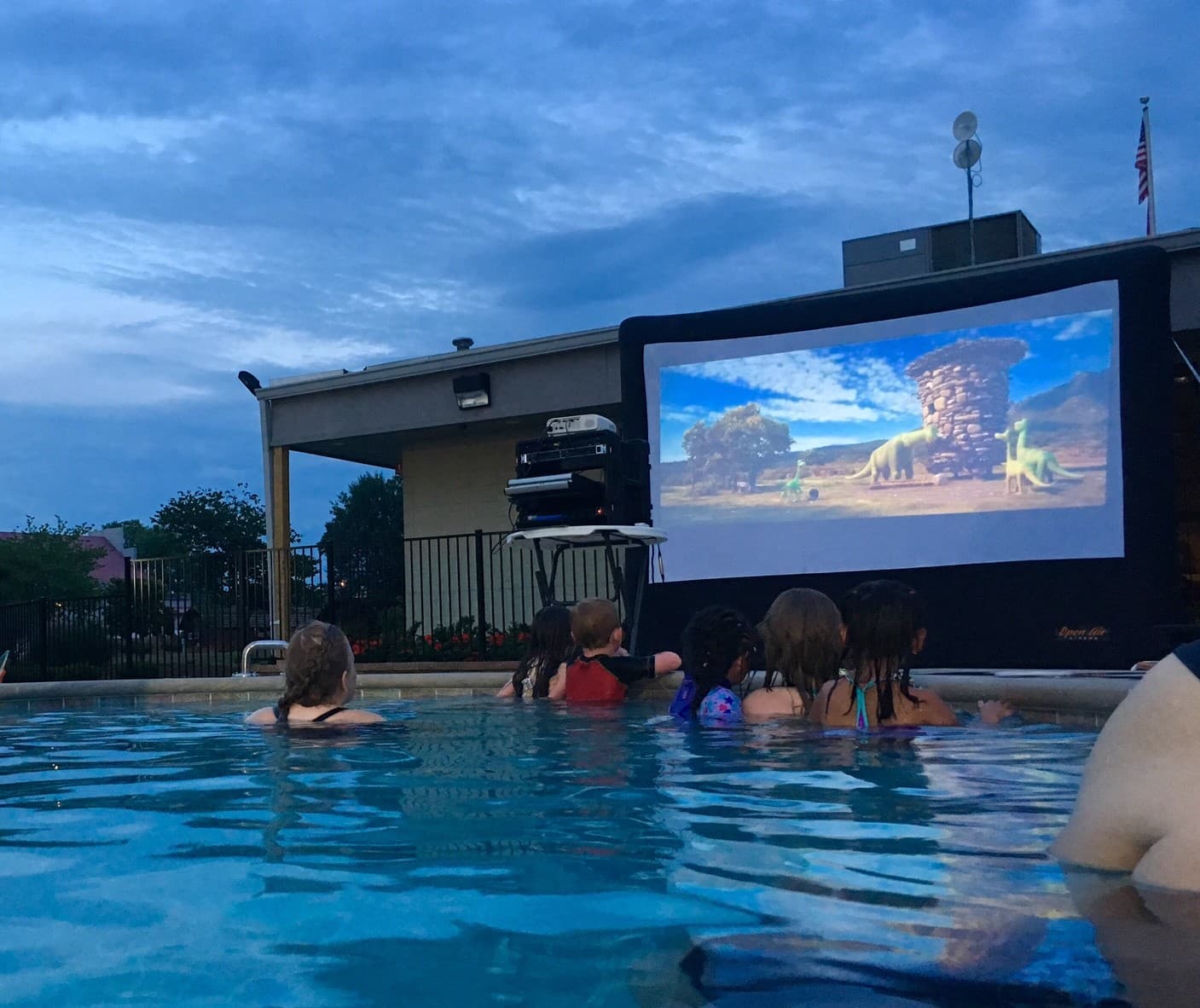 kids in a pool watching outdoor movie screen at the Nashville KOA 