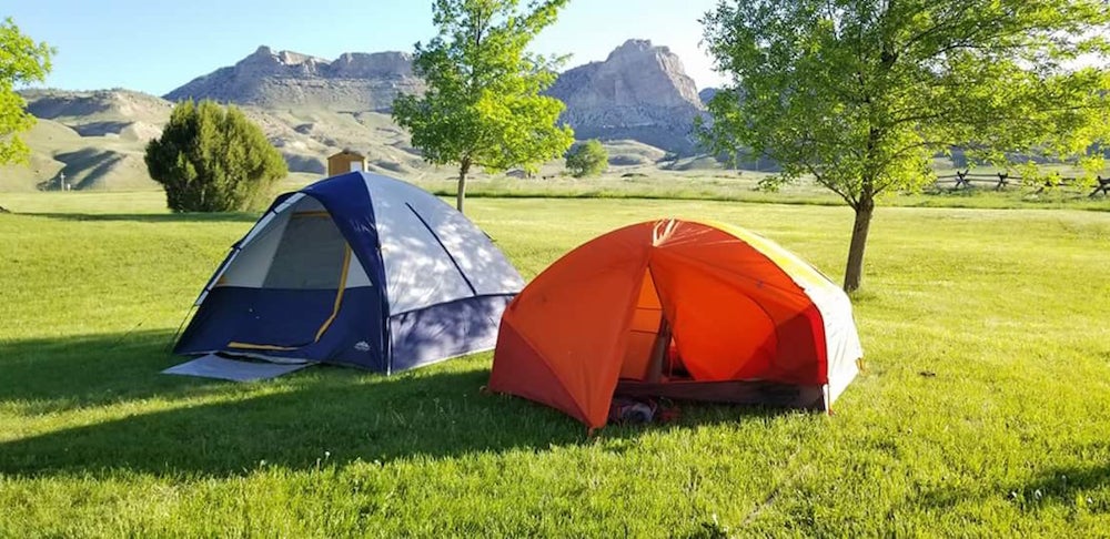 Two tents in field at Buffalo State Park with mountains visible in the background