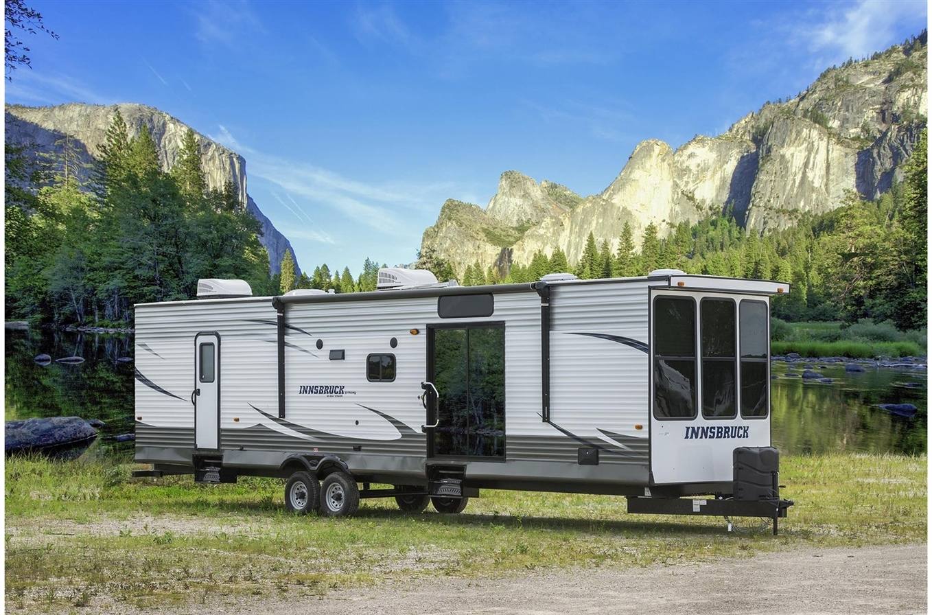 a destination trailer set up in a valley campsite with mountains in the background