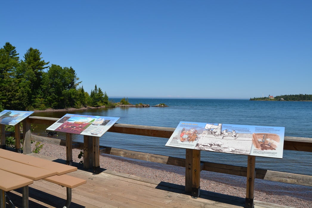 lake view beside benches and infographic signs.