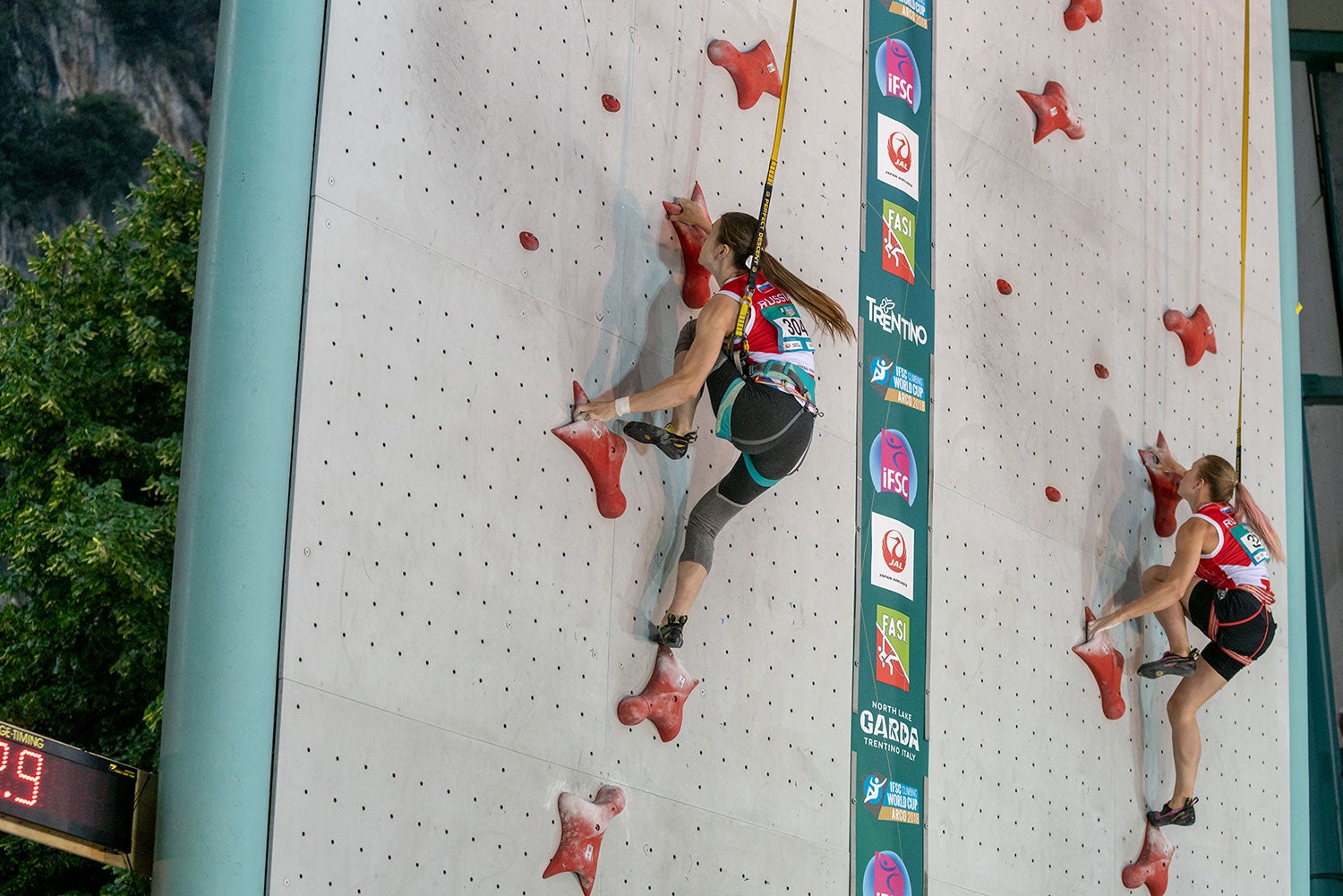 Two women climbing indoors side by side 