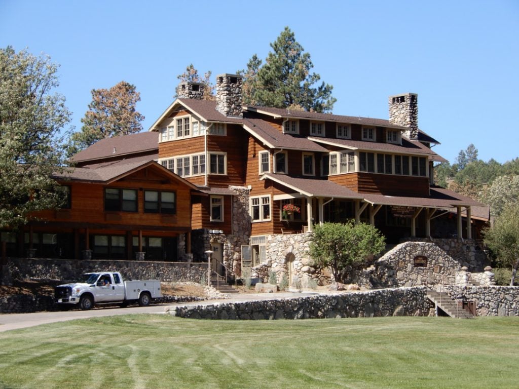 a manicured front lawn and the towering state game lodge in custer state park