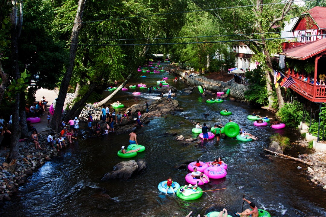 people in inner tubes float down a river