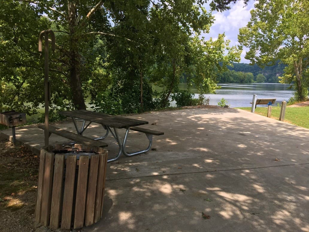 picnic table on concrete slab at Campsite with river access at Harpeth River Bridge Campground