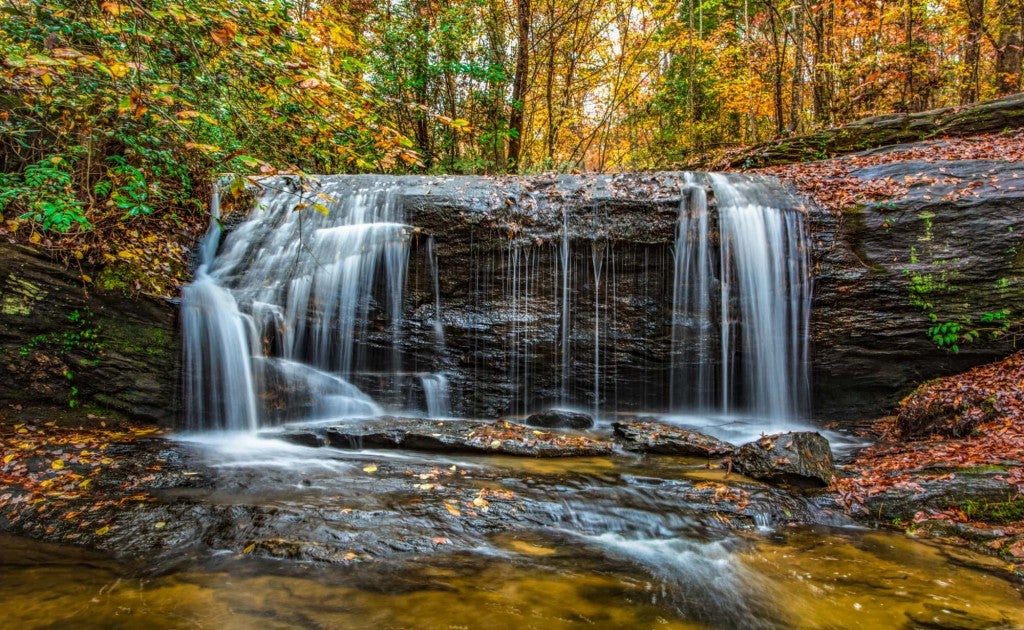 Panoramic photo of waterfall in SC with fall foliage in the background