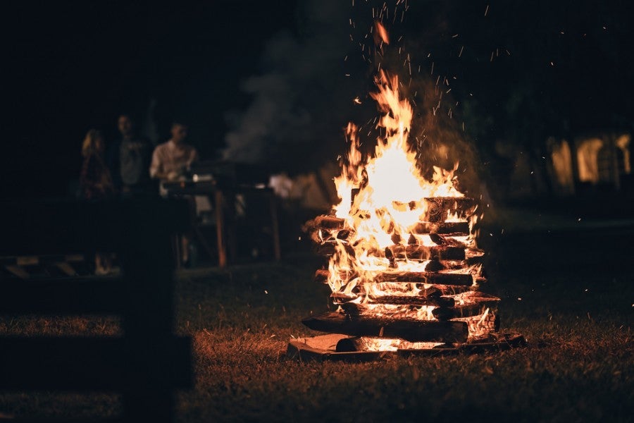 log cabin style campfire burning intensely in a fire ring at night