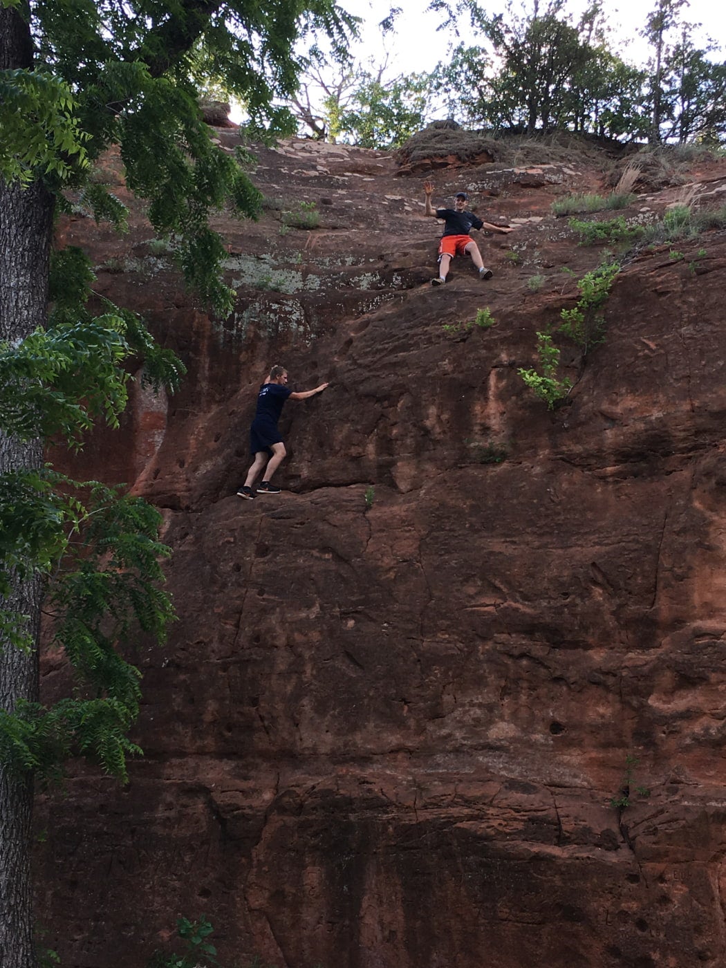 two men bouldering on natural rock wall in an oklahoma state park