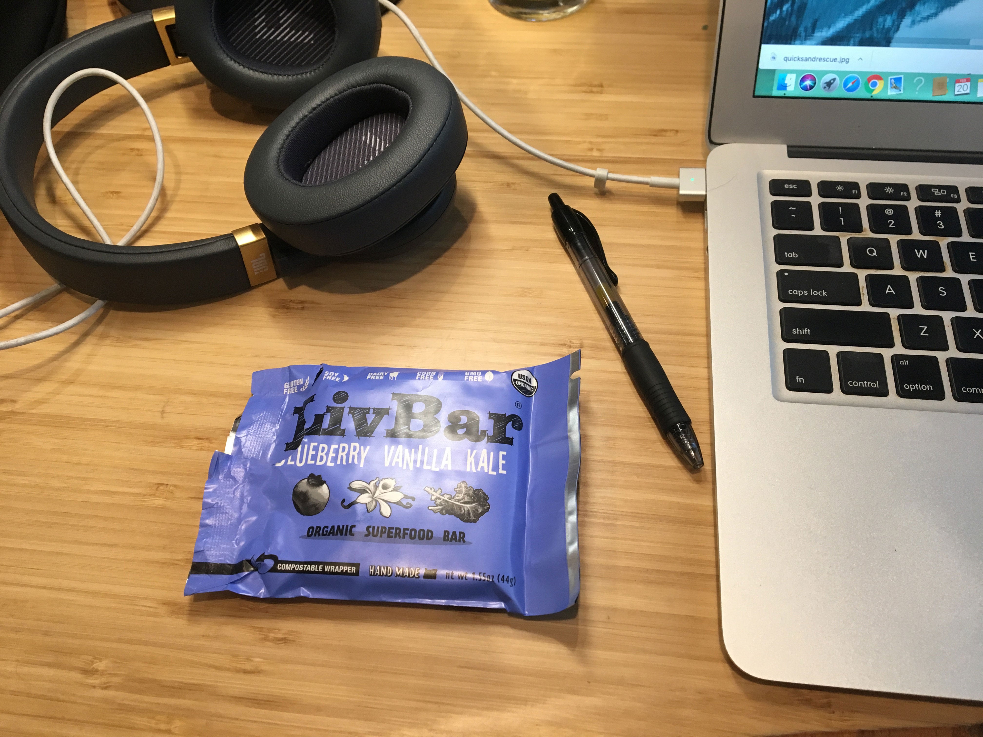 blueberry vanilla kale LivBar on a desk surrounded by laptop and headphones