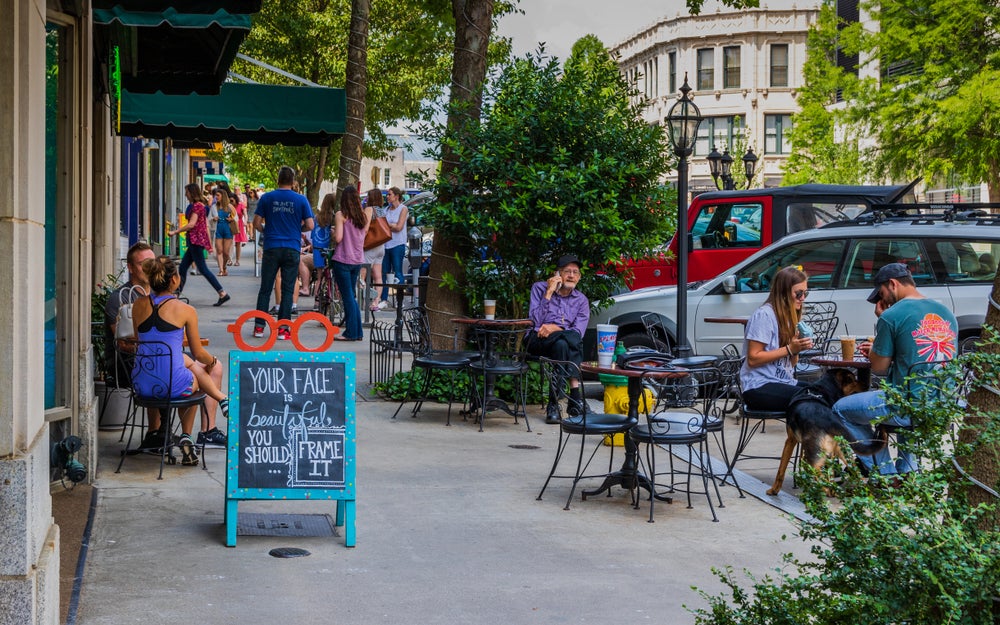 people stop at cafes and stores along busy street in asheville, nc