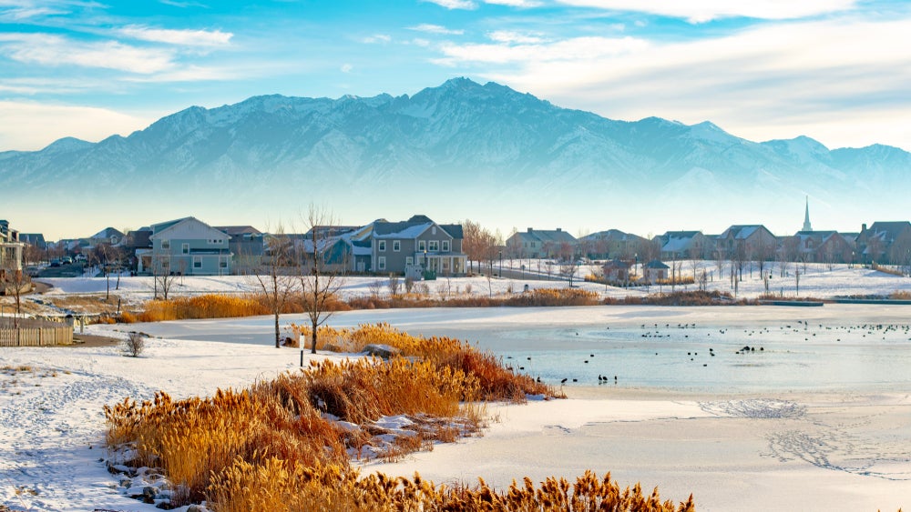 A suburban Salt Lake neighborhood on a frozen lake in winter surrounded by a foggy inversion with mountains in the background.