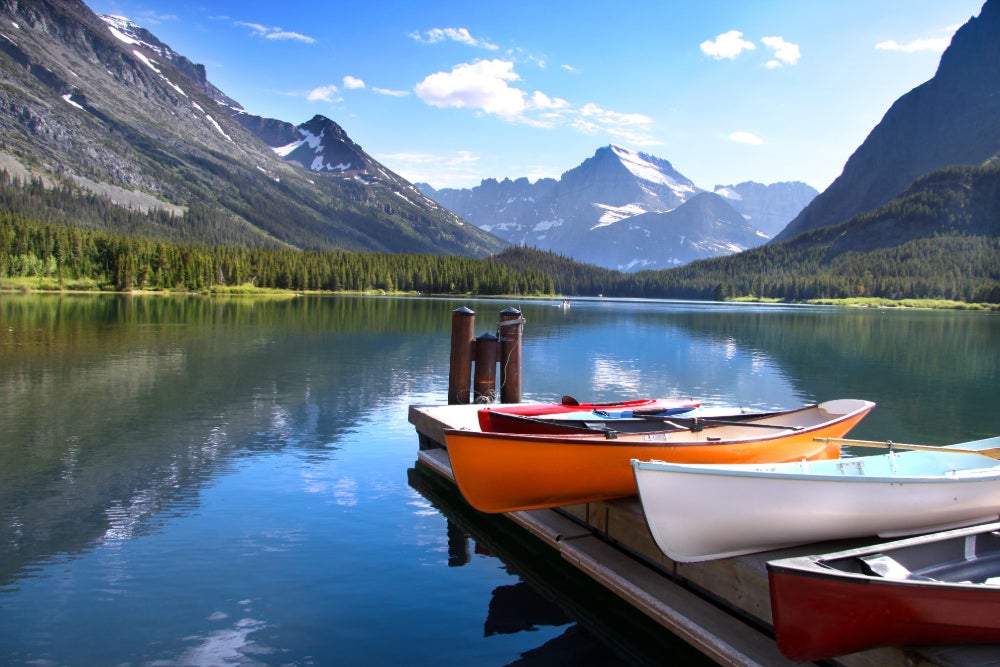 three canoes docked on a pier on lake mcdonald at glacier national park